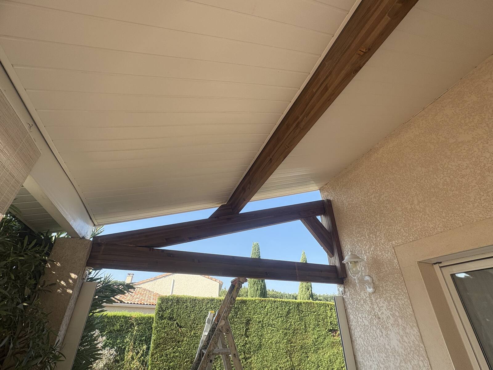 Charpente en bois d'une terrasse couverte, poutres apparentes